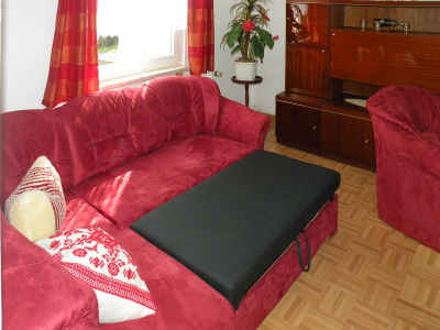 Die moderne neue Couch bietet im Wohnzimmer eine Aufbettungsmöglichkeit für einen dritten Gast